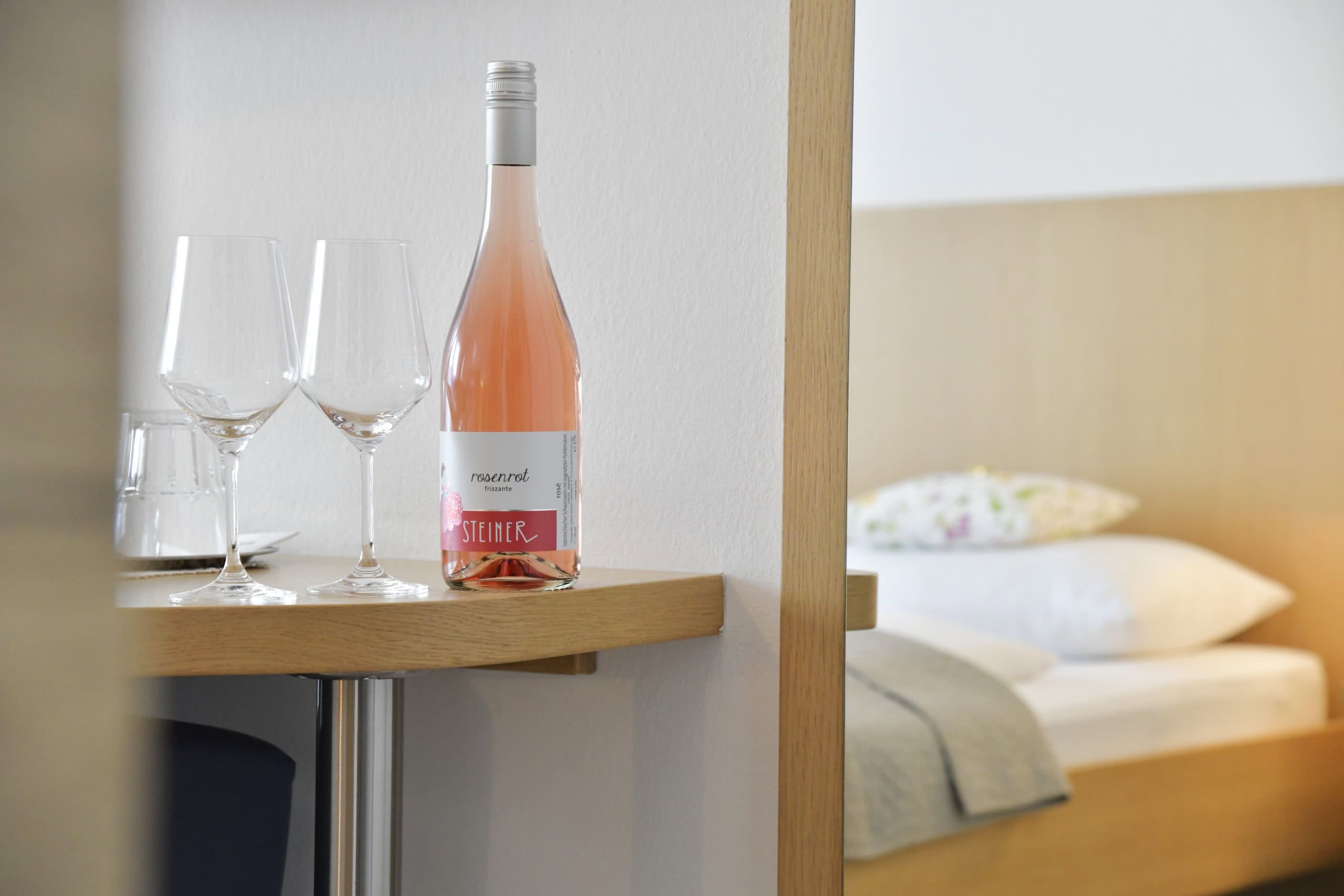 Flasche Wein mit zwei Gläsern im Zimmer Haus Mariella