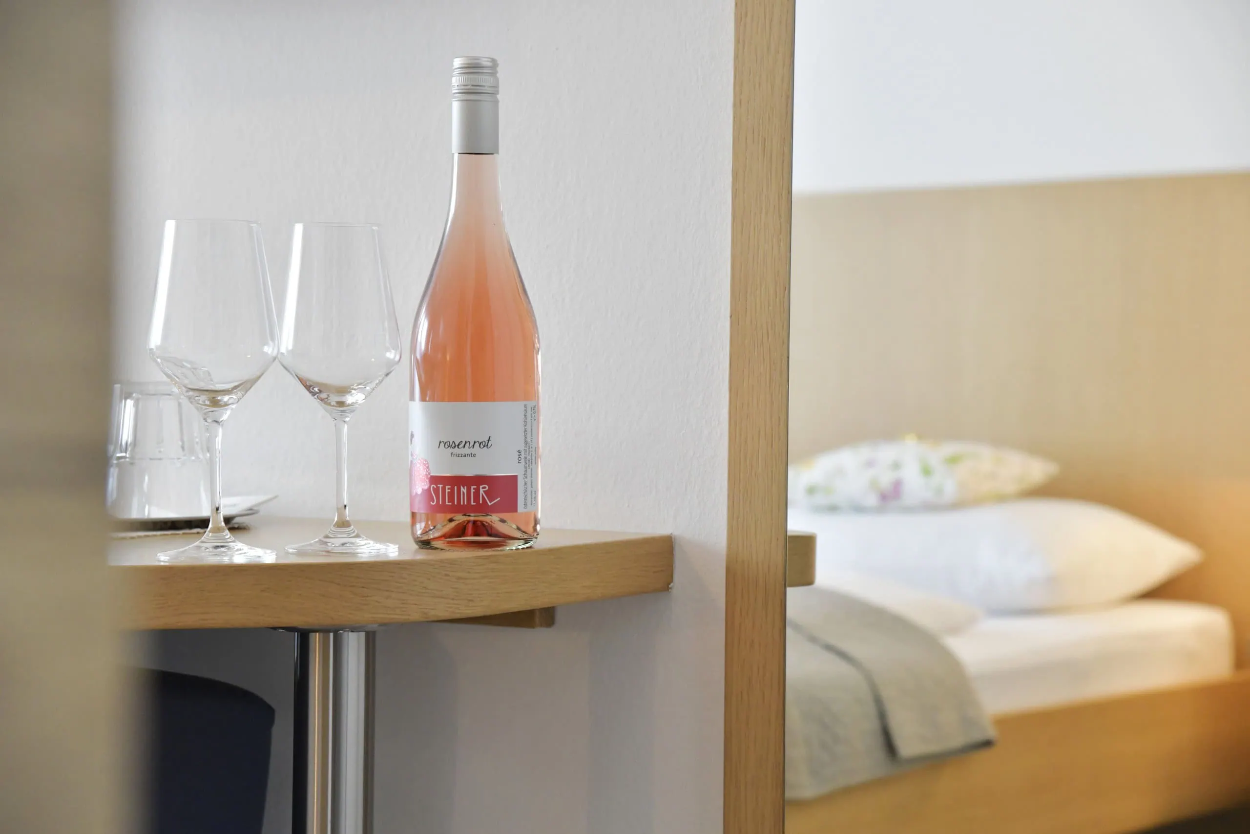 Flasche Wein mit zwei Gläsern im Zimmer Haus Mariella